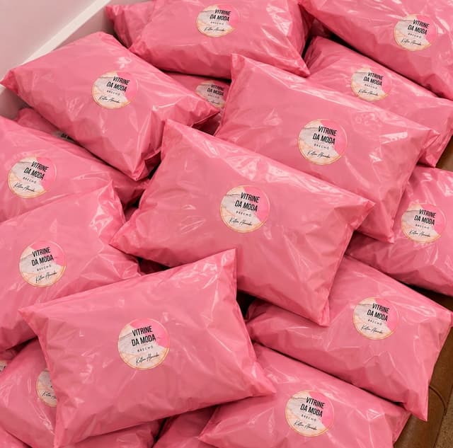 Pilha de envelopes rosa da Vitrine da Moda, cada um com o selo redondo da loja